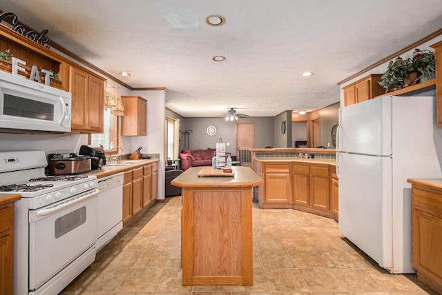 2256 Moulder Dr, Niles, MI 49120 - kitchen with white appliances, a peninsula, light countertops, a kitchen island, and ceiling fan