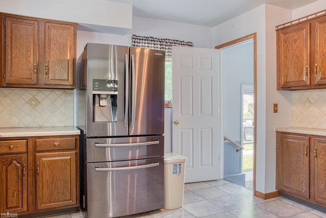 538 Dimmick St, Owosso, MI 48867 - kitchen featuring stainless steel refrigerator with ice dispenser, brown cabinetry, backsplash, and light countertops