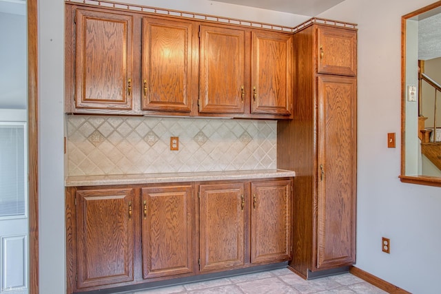 538 Dimmick St, Owosso, MI 48867 - kitchen with light countertops, brown cabinetry, and tasteful backsplash