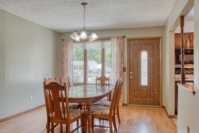 538 Dimmick St, Owosso, MI 48867 - dining area with light wood-style floors, a chandelier, and a textured ceiling