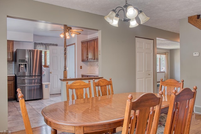 538 Dimmick St, Owosso, MI 48867 - dining area with a chandelier, a ceiling fan, a textured ceiling, and light wood finished floors