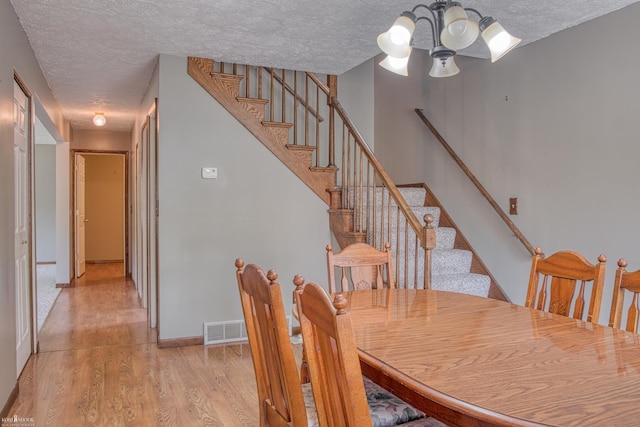 538 Dimmick St, Owosso, MI 48867 - dining space with a textured ceiling, light wood-style floors, and stairway