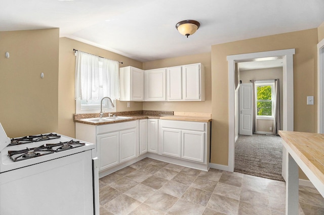 705 E Dowland St, Ludington, MI 49431 - kitchen with white gas stove and white cabinetry