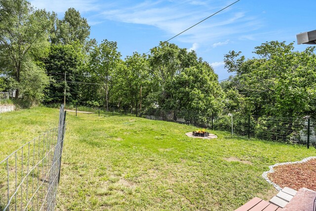 705 E Dowland St, Ludington, MI 49431 - fenced backyard with a fire pit