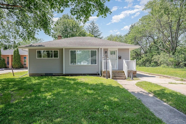 2411 Sheridan Ave, Saginaw, MI 48601 - view of front of house featuring a chimney, a front lawn, and roof with shingles