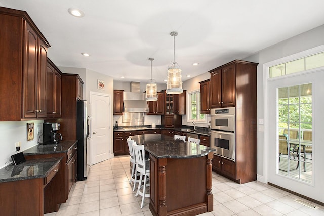 7251 Beverly Dr, South Haven, MI 49090 - kitchen with appliances with stainless steel finishes, wall chimney range hood, healthy amount of natural light, a kitchen island, and recessed lighting