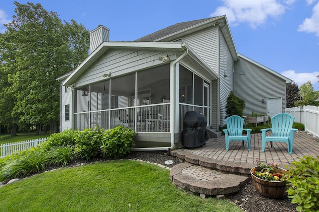 7251 Beverly Dr, South Haven, MI 49090 - rear view of house with a patio area, a sunroom, and a chimney