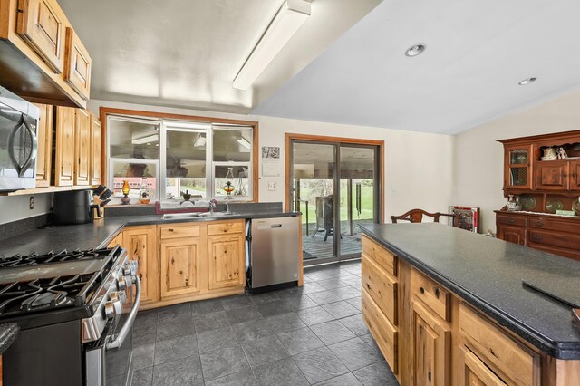7350 Cedar Creek Rd, Delton, MI 49046 - kitchen with stainless steel appliances, dark countertops, vaulted ceiling, and recessed lighting
