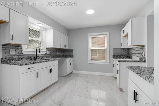 18504 Sussex St, Detroit, MI 48235 - kitchen featuring light marble finish floors, dark stone counters, backsplash, and white cabinets