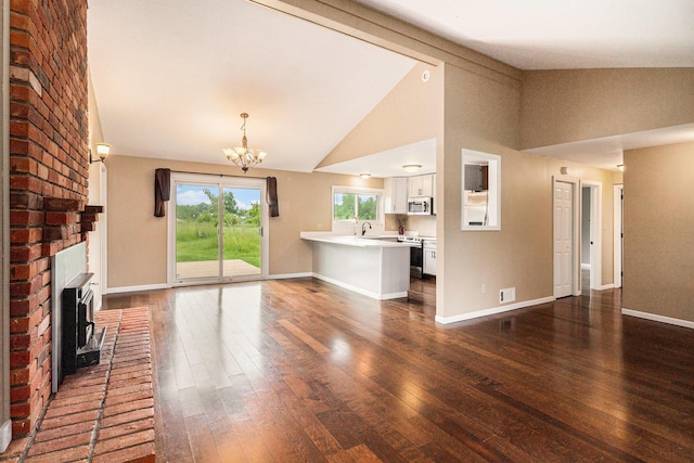8175 Chamberlin Rd, Dexter, MI 48130 - unfurnished living room featuring dark wood-type flooring, a chandelier, and high vaulted ceiling
