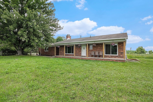 8175 Chamberlin Rd, Dexter, MI 48130 - view of front of home with brick siding, a front lawn, a chimney, and a porch