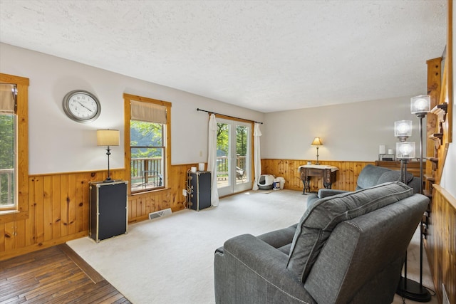 6860 Ashley Ave NE, Belding, MI 48809 - living room featuring wainscoting, wood walls, a textured ceiling, and hardwood / wood-style floors