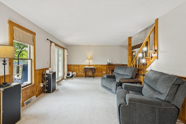 6860 Ashley Ave NE, Belding, MI 48809 - living room featuring wainscoting, wood walls, light colored carpet, and stairs