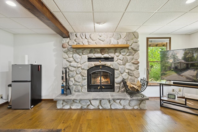 6860 Ashley Ave NE, Belding, MI 48809 - living area with a drop ceiling, a stone fireplace, and wood-type flooring