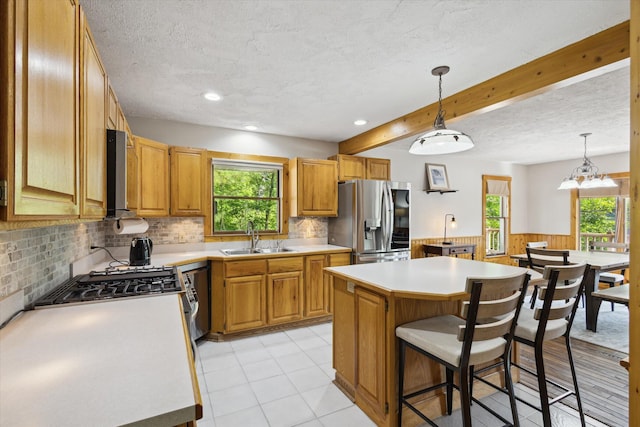 6860 Ashley Ave NE, Belding, MI 48809 - kitchen featuring stainless steel fridge, healthy amount of natural light, a center island, a wainscoted wall, and light countertops