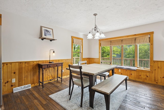 6860 Ashley Ave NE, Belding, MI 48809 - dining area featuring a wainscoted wall, wooden walls, a textured ceiling, wood-type flooring, and a chandelier