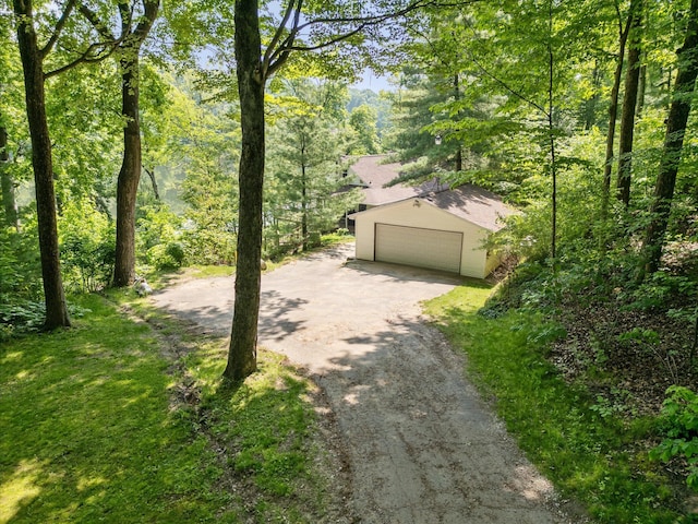 6860 Ashley Ave NE, Belding, MI 48809 - view of front of house featuring an outbuilding, a garage, dirt driveway, and a view of trees