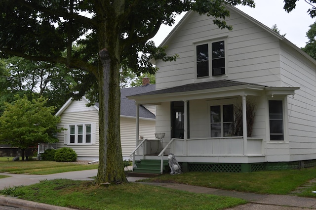 517 Winchester Ave, Saint Joseph, MI 49085 - view of front of home featuring a porch, a front lawn, and a shingled roof