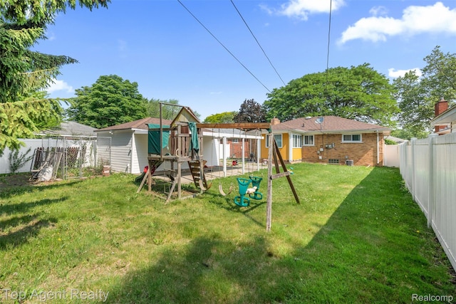 17090 Collinson Ave, Eastpointe, MI 48021 - rear view of property featuring a playground, brick siding, and a fenced backyard