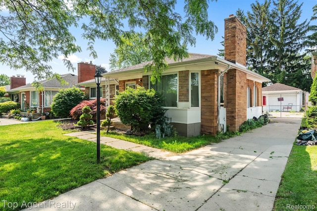 17090 Collinson Ave, Eastpointe, MI 48021 - view of front of house with a chimney, a front yard, and a detached garage