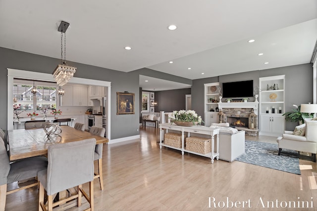 3794 Lake Birch St NE, Grand Rapids, MI 49525 - living area with recessed lighting, light wood-type flooring, a fireplace, built in shelves, and a chandelier