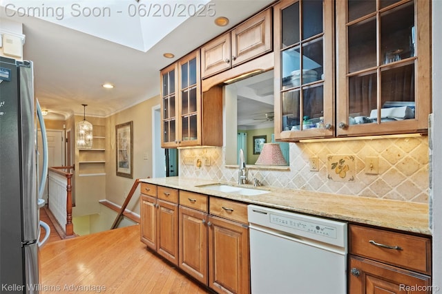 34030 Hampshire St, Livonia, MI 48154 - kitchen with dishwasher, freestanding refrigerator, light wood finished floors, decorative backsplash, and brown cabinetry