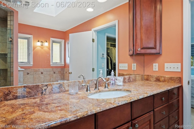 34030 Hampshire St, Livonia, MI 48154 - bathroom with vanity, a walk in closet, a skylight, and a tile shower