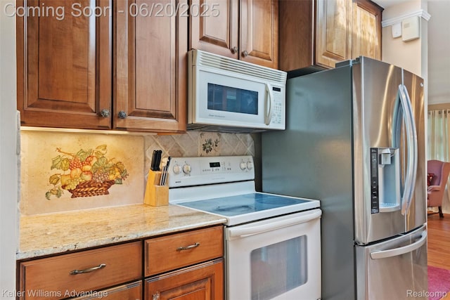 34030 Hampshire St, Livonia, MI 48154 - kitchen featuring white appliances, decorative backsplash, brown cabinetry, light stone counters, and wood finished floors