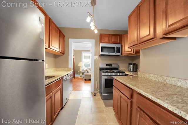 136 Alice Ave, Bloomfield Hills, MI 48302 - kitchen with appliances with stainless steel finishes, brown cabinets, light stone countertops, and light tile patterned floors