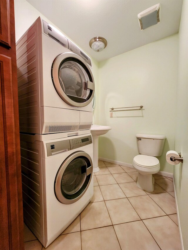 8456 Torreyhill Ct, Elmira, MI 49730 - washroom with estacked washer and dryer and tile patterned flooring