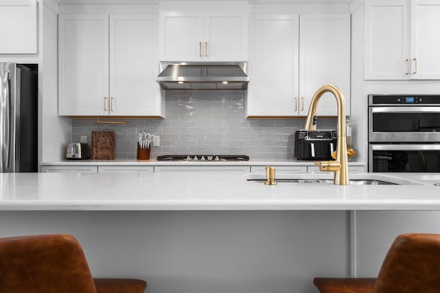 2949 Aughton Rd, Ann Arbor, MI 48105 - kitchen featuring extractor fan, stainless steel appliances, decorative backsplash, and light countertops