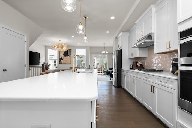 2949 Aughton Rd, Ann Arbor, MI 48105 - kitchen featuring appliances with stainless steel finishes, a spacious island, a chandelier, under cabinet range hood, and recessed lighting