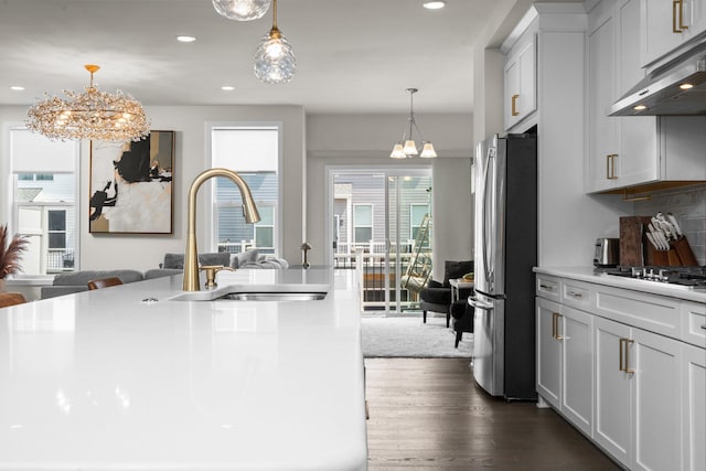 2949 Aughton Rd, Ann Arbor, MI 48105 - kitchen with freestanding refrigerator, under cabinet range hood, gas stovetop, dark wood finished floors, and open floor plan