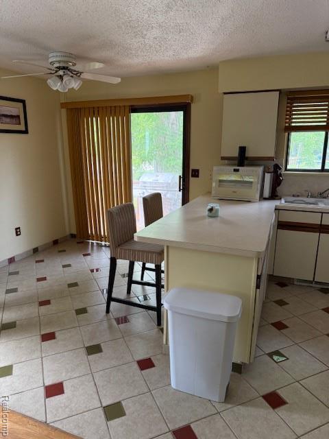 5496 Elizabeth Lake Rd, Waterford, MI 48327 - dining area featuring a textured ceiling, light tile patterned floors, and a ceiling fan