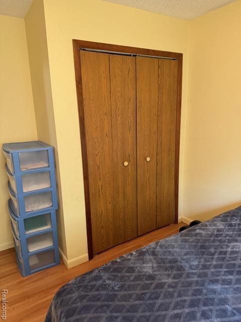 5496 Elizabeth Lake Rd, Waterford, MI 48327 - bedroom with wood finished floors and a closet