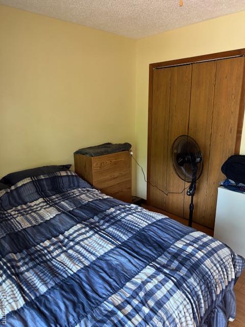 5496 Elizabeth Lake Rd, Waterford, MI 48327 - bedroom with a textured ceiling, wood finished floors, and a closet