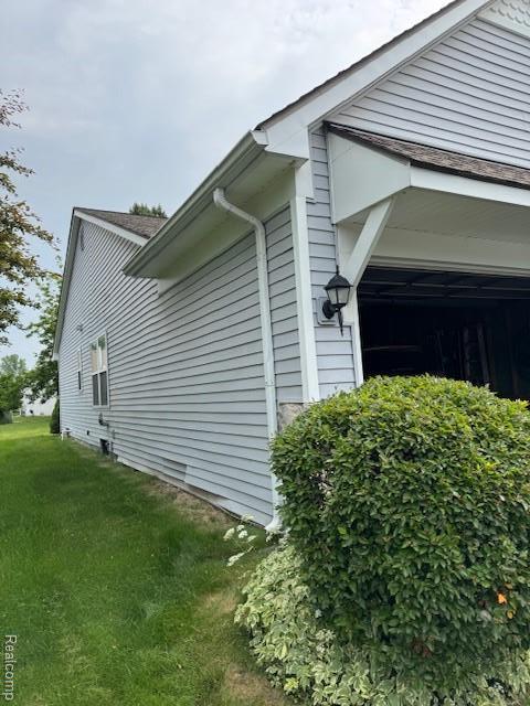 912 Rikki Anne Ct, Wixom, MI 48393 - view of home's exterior with a garage and a lawn