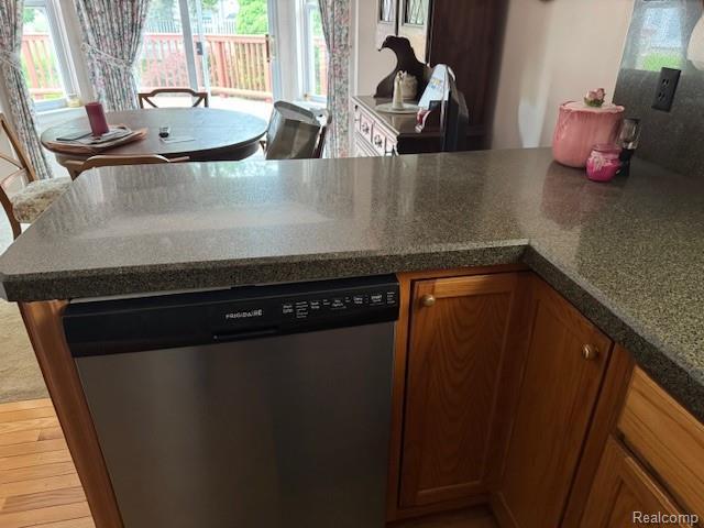 912 Rikki Anne Ct, Wixom, MI 48393 - kitchen featuring dishwasher, plenty of natural light, brown cabinetry, and dark countertops