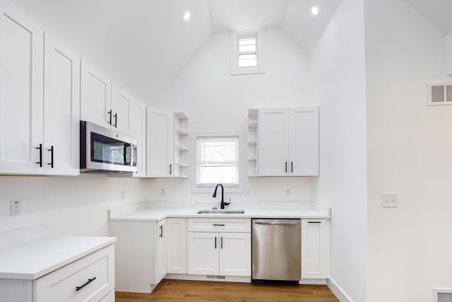 21611 Conners Ave, Warren, MI 48091 - kitchen featuring stainless steel appliances, open shelves, white cabinets, healthy amount of natural light, and high vaulted ceiling