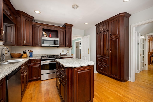 1208 Whittier Rd, Ypsilanti, MI 48197 - kitchen featuring stainless steel appliances, light wood-style flooring, recessed lighting, light stone counters, and a kitchen island