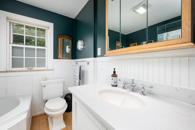 1208 Whittier Rd, Ypsilanti, MI 48197 - bathroom featuring a garden tub, wainscoting, wood finished floors, and vanity