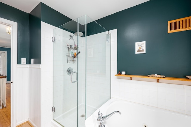 1208 Whittier Rd, Ypsilanti, MI 48197 - bathroom featuring a shower stall, a whirlpool tub, wood finished floors, and wainscoting