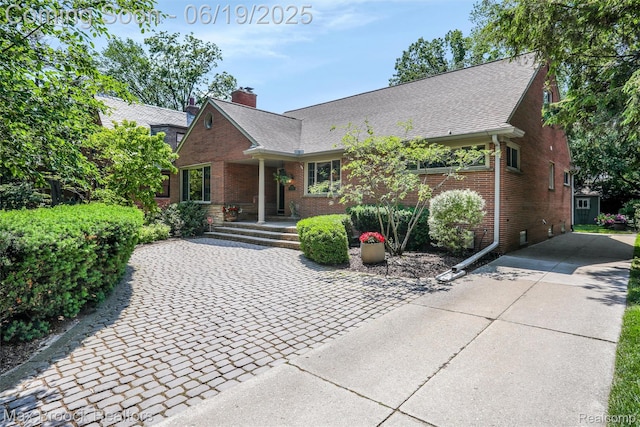 25845 Salem Rd, Huntington Woods, MI 48070 - view of front facade with concrete driveway, brick siding, and a chimney