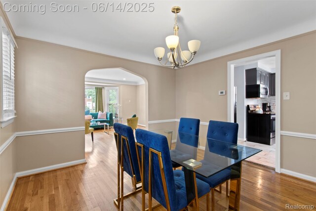 16136 Whitcomb St, Detroit, MI 48235 - dining space featuring arched walkways, a chandelier, light wood finished floors, and crown molding