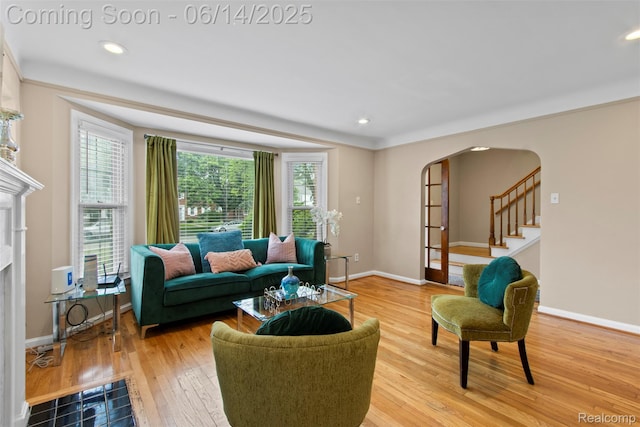 16136 Whitcomb St, Detroit, MI 48235 - living room featuring arched walkways, a fireplace with flush hearth, light wood finished floors, recessed lighting, and stairs