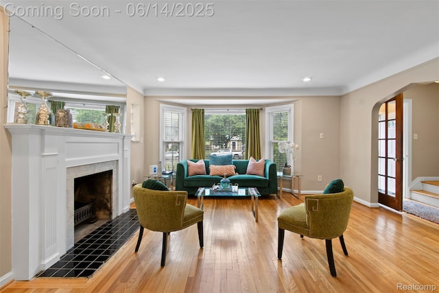 16136 Whitcomb St, Detroit, MI 48235 - living room with arched walkways, wood finished floors, a tile fireplace, recessed lighting, and stairs