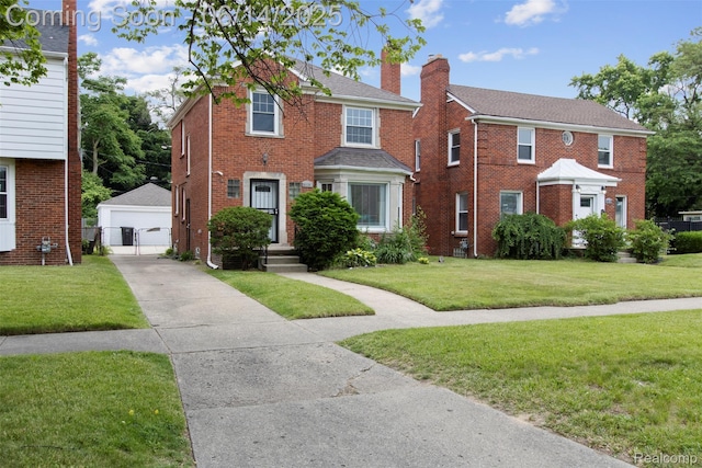 16136 Whitcomb St, Detroit, MI 48235 - view of front facade featuring an outdoor structure, a chimney, a front lawn, a garage, and brick siding