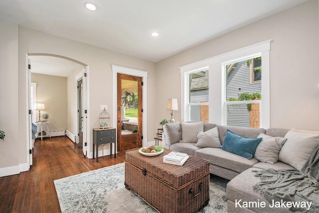 947 W Main St, Ionia, MI 48846 - living room with arched walkways, plenty of natural light, dark wood finished floors, recessed lighting, and a baseboard radiator