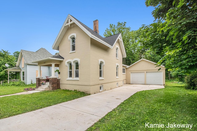 947 W Main St, Ionia, MI 48846 - view of front of home with a garage, an outdoor structure, a chimney, a front yard, and brick siding