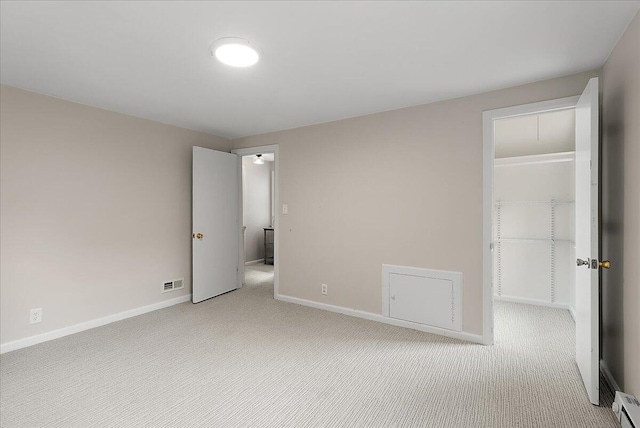 1115 Keneberry Way SE, East Grand Rapids, MI 49506 - unfurnished bedroom featuring a spacious closet, light colored carpet, a closet, and a baseboard heating unit